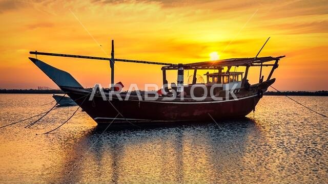 قارب منفرد على شاطئ الدمام مع منظر شروق الشمس في الخلفية. الدمام، المملكة العربية السعودية.
