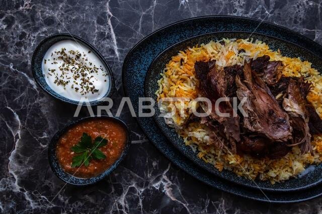 طبق من الكبسة أو المندي، والأرز ولحم الضأن المشوي، وطبقين صغيرين من الزبادي والصلصة الحارة.