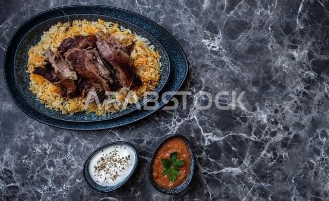طبق من الكبسة أو المندي، والأرز ولحم الضأن المشوي، وطبقين صغيرين من الزبادي والصلصة الحارة.