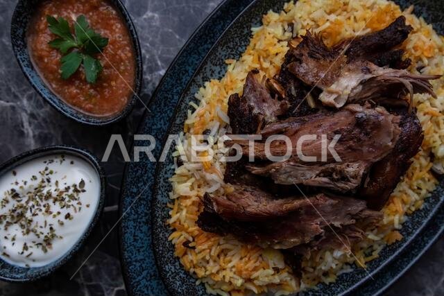 طبق من الكبسة أو المندي، والأرز ولحم الضأن المشوي، وطبقين صغيرين من الزبادي والصلصة الحارة.