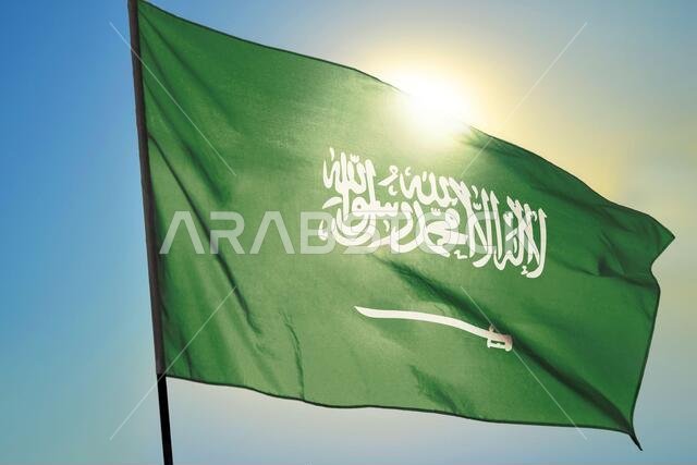 Saudi Arabia flag waving on the wind in front of sun