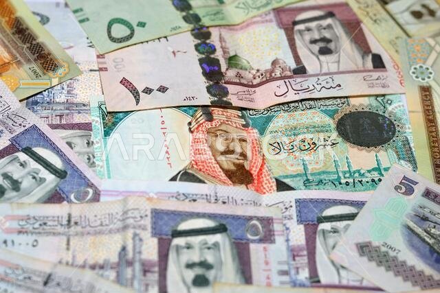 مجموعة من خلفيات العملات السعودية، ومجموعة مختلفة من الريالات السعودية من فئات 100 و50 و20 و10 و5 و1 ريال، مع التركيز بشكل انتقائي على العملات السعودية.