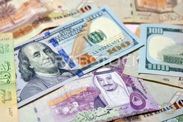 Saudi Arabia currency with USA dollar banknotes. blurred money . Saudi money and American dollars exchange rate, 100 dollars , different  Saudi riyals