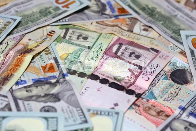 Saudi Arabia currency with USA dollar banknotes. blurred money . Saudi money and American dollars exchange rate, 100 dollars , different  Saudi riyals