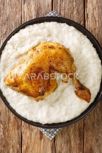 Saleeg Saudi Arabia's favourite chicken and rice dish closeup in the plate on the table. Vertical top view from above