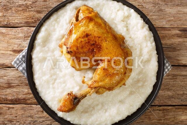 Saudi Arabia dish Saleeg of creamy rice served with chicken close-up in a plate on the table. horizontal top view from above