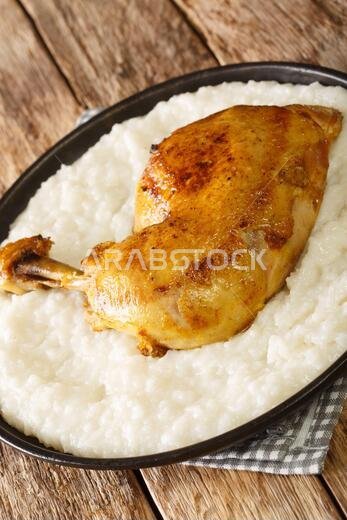 صورة مقربة لطبق السليغ، وهو طبق الدجاج والأرز المفضل في السعودية، موضوع على الطاولة. (صورة عمودية)