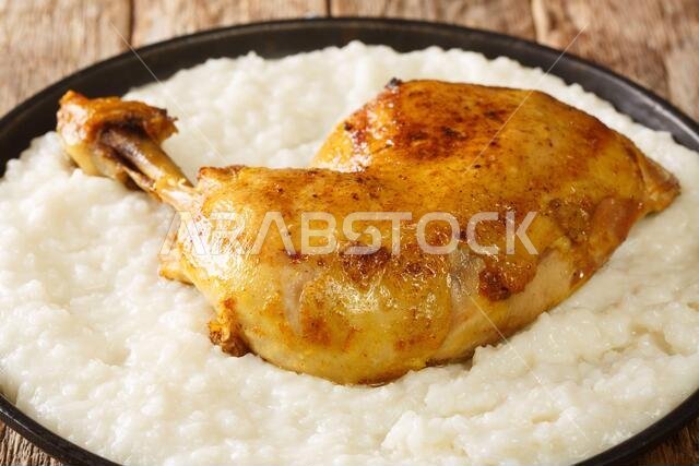 Saudi Arabia dish Saleeg of creamy rice served with chicken close-up in a plate on the table. horizontal