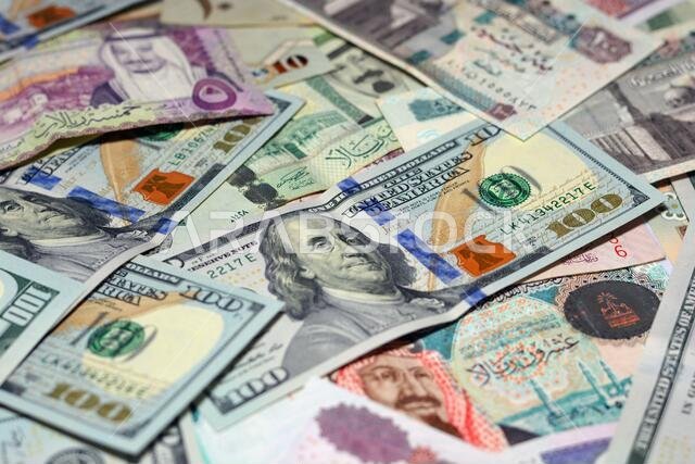 Saudi Arabia currency with USA dollar banknotes. blurred money . Saudi money and American dollars exchange rate, 100 dollars , different  Saudi riyals