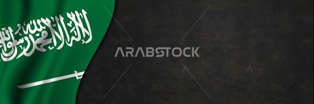 علم المملكة العربية السعودية على جدار خرساني. لافتة تحمل نسيج علم المملكة العربية السعودية.
