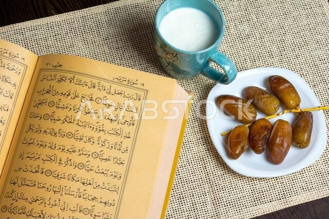 Top view of the Holy Quran and Algerian dates with a mug of milk, Ramadan concept