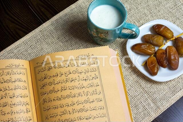 Top view of the Holy Quran and Algerian dates with a mug of milk, Ramadan concept