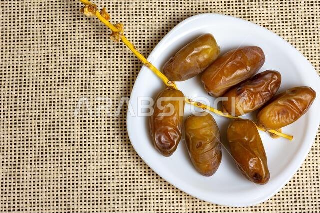 Close-up of Algerian royal dates on a white plate, Ramadan concept