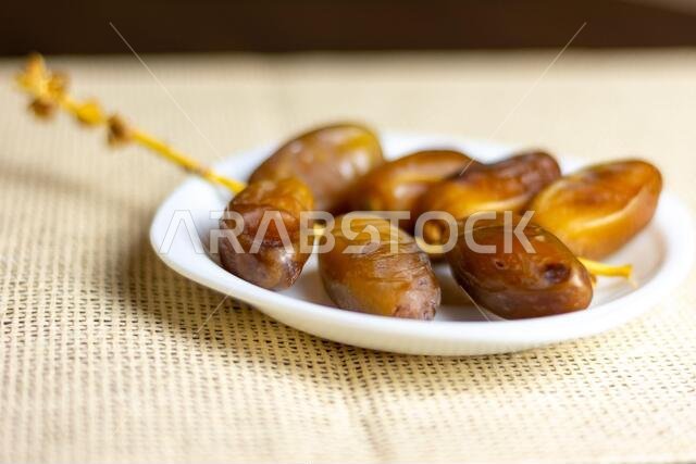 صورة مقرّبة لتمور جزائرية ملكية على طبق أبيض، مفهوم رمضان