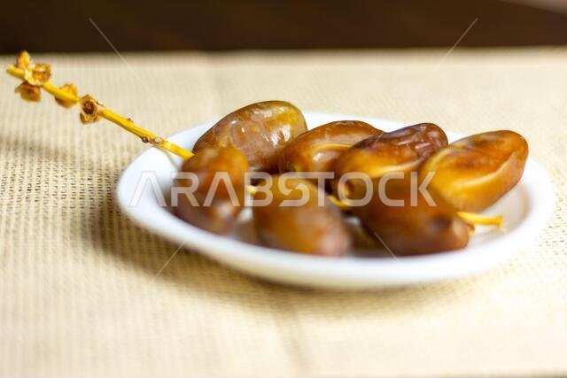 صورة مقرّبة لتمور جزائرية ملكية على طبق أبيض، مفهوم رمضان