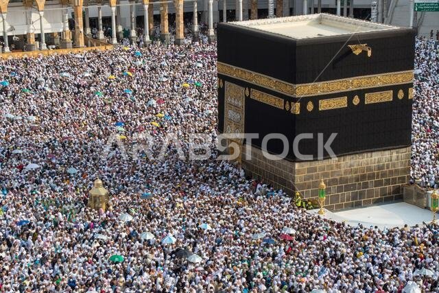 حجاج مسلمون يطوفون حول الكعبة المشرفة في مكة المكرمة بالمملكة العربية السعودية. مسلمون يصلّون معاً في هذا المكان المقدس.