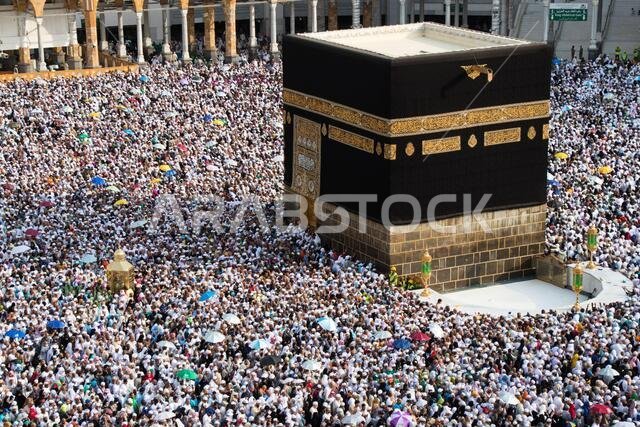 حجاج مسلمون يطوفون حول الكعبة المشرفة في مكة المكرمة بالمملكة العربية السعودية. مسلمون يصلّون معاً في هذا المكان المقدس.