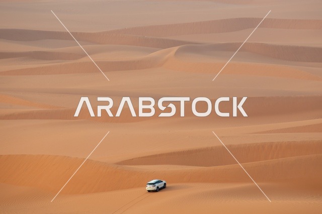 White SUV Driving Through Al-Nafud Desert Dunes