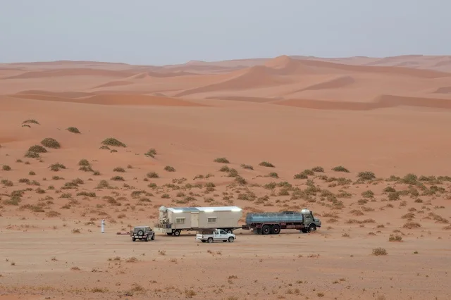 Mobile Caravan and Vehicles in Desert Dunes