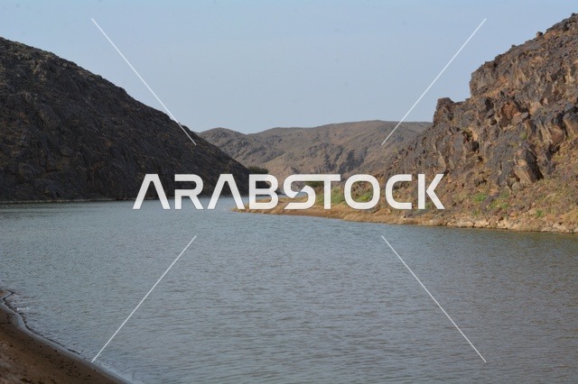 مجرى مائي يتدفق بين الجبال الصخرية في السعودية