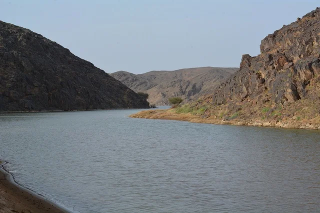 مجرى مائي يتدفق بين الجبال الصخرية في السعودية