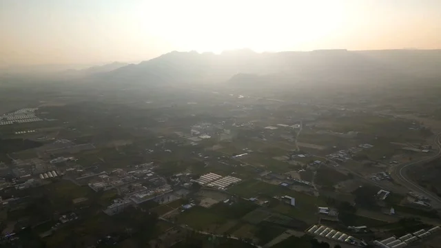 قلعة رعوم في نجران مع لقطة جوية للجبال وقت الغام الغروب