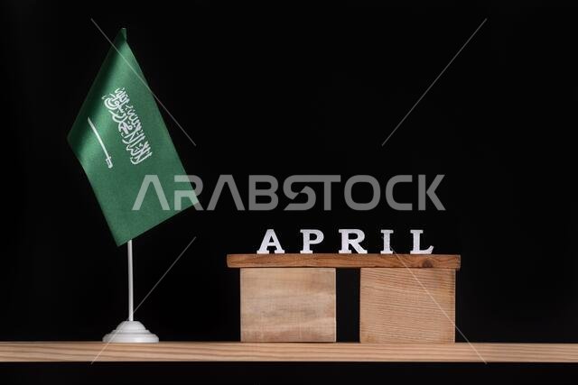 Wooden calendar of April with Saudi Arabia flag on black background. Dates of Saudi Arabia in April.