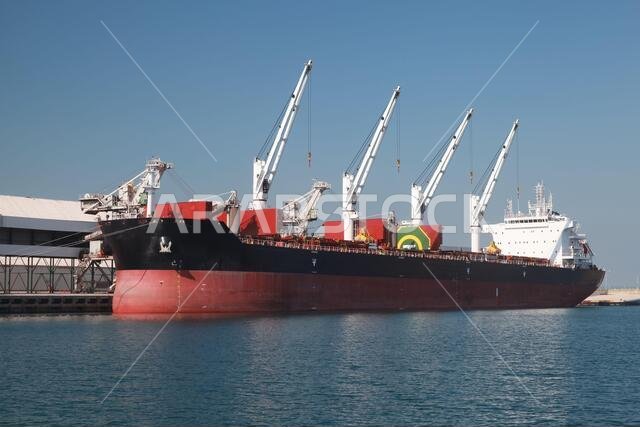 Bulk carrier ship is loading in a port on a sunny day. Red sea, Saudi Arabia