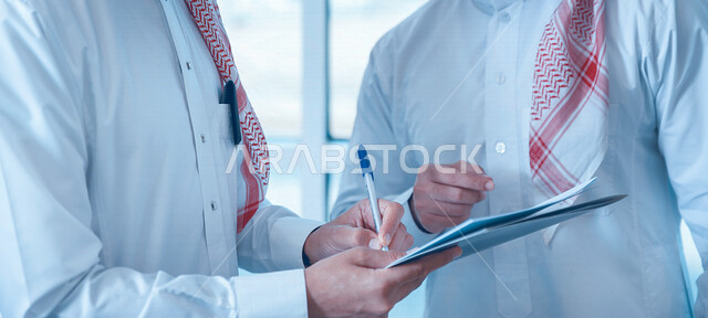 صورة مقربة لفريق عمل عربي خليجي سعودي يقوم بمتابعة ومناقشة الأعمال داخل مقر الشركة، كتابة وتدوين الملاحظات، مهن وأعمال تجارية، شركة سعودية، بيئة عمل، زملاء عمل، إدارة أعمال الشركة، تطوير المشاريع، عقد صفقات تجارية