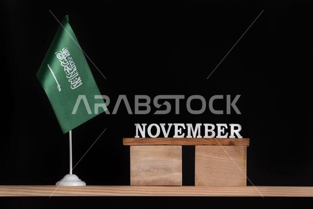 Wooden calendar of November with Saudi Arabia flag on black background. Dates of Saudi Arabia in November.