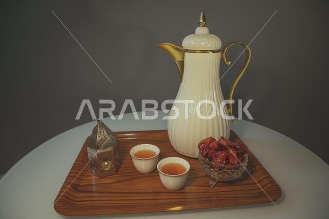 تمر، قهوة عربية، وفانوس إسلامي داخل وعاء خشبي. رمز رمضان