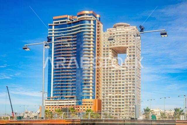 مبانٍ سكنية وتجارية على الكورنيش مع أعمدة إنارة مضمار السباق في المقدمة، جدة، المملكة العربية السعودية