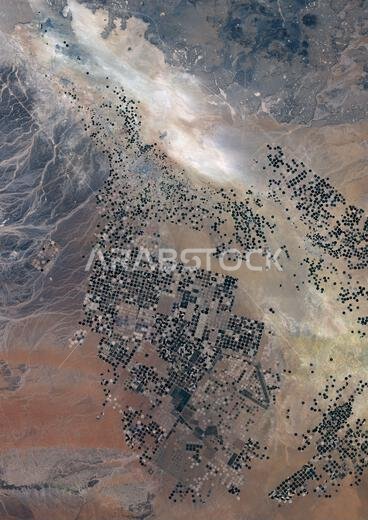 Color satellite image of agricultural fields in the Wadi As-Sirhan Basin, Saudi Arabia in 2022. The fields are irrigated by water pumped from underground aquifers. That water is distributed in rotation about a center point within a circular field—a technique known as center-pivot agriculture.