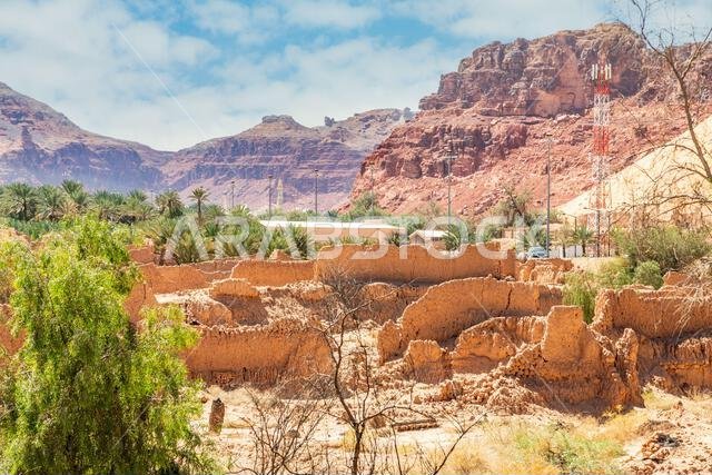 Al Ula ruined arab village houses ruins with road and rocky landscape in the background , Saudi Arabia