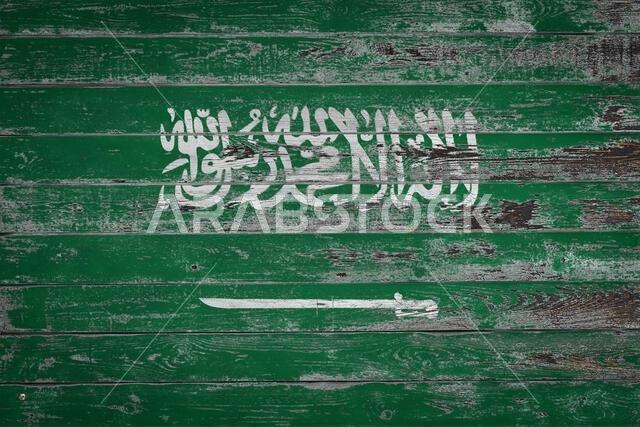 العلم الوطني للمملكة العربية السعودية مرسوم على ألواح خشبية غير مستوية. رمز الدولة.