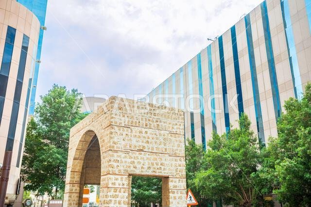 قوس باب الفردة القديم محاط بمبانٍ مكتبية حديثة في شارع البلد، جدة، المملكة العربية السعودية