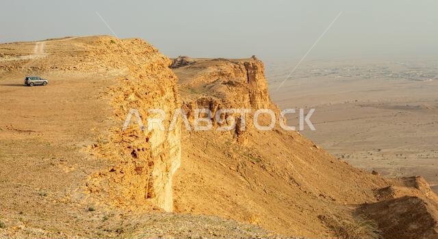 Car on the edge of the Jabal Tuwaiq Mountains, with desert landscape, Riyadh, Saudi Arabia