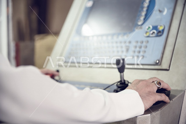 مهندس عربي خليجي سعودي داخل مصنع الحديد يستخدم جهاز خاص بالمصنع ، مشرف على عملية انتاج الحديد ، مفهوم الهندسة والتصنيع