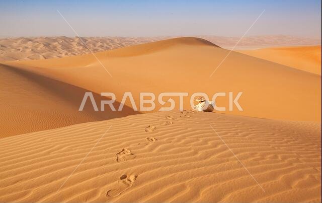 رجل عربي يرتدي زياً تقليدياً على كثيب رملي في الصحراء العربية