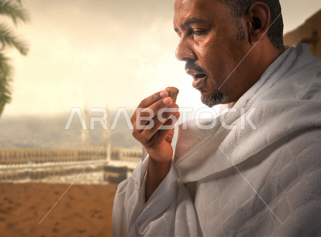 رجل عربي خليجي سعودي يرتدي لباس الاحرام ويتناول حبة التمر، افطار الصائم، تناول الضيافة الرمضانية، اداء العمرة في شهر رمضان، اداء فريضة الحج، العبادة والتقرب الى الله، زيارة بيت الله الحرام، اسلاميات وعبادة