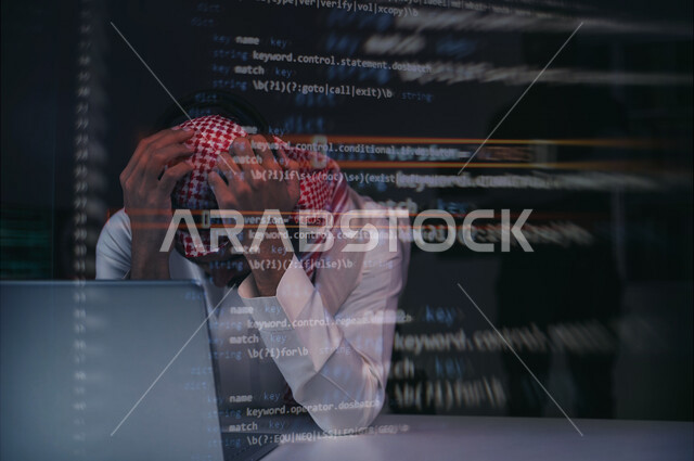 رجل عربي خليجي سعودي يجلس امام الحاسوب المحمول بايماءات تدل على الحزن، التعرض للإختراق والهجمات الالكترونية، سرقة كلمات المرور والبيانات الشخصية، اختراق النظام والبيانات، الجرائم الاكترونية، اكواد برمجية، خلفية للغة البرمجة