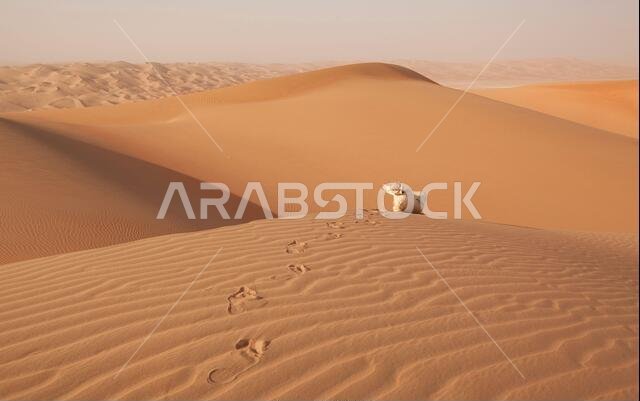 رجل عربي يرتدي زياً تقليدياً على كثيب رملي في الصحراء العربية