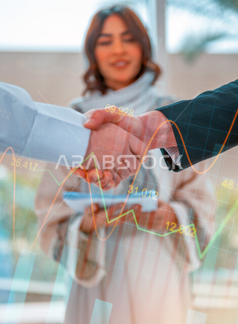 Two businessmen shake hands to complete a profitable deal, a business agreement, a project and a new business plan, business partners, progress and success, a Saudi company with high efficiency, hologram graphics.