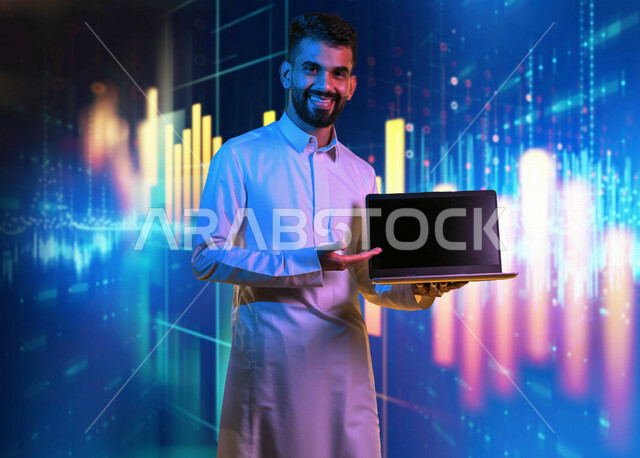 رجل عربي سعودي خليجي يحمل بيده جهاز الحاسوب، عرض شاشه سوداء على جهاز اللابتوب, خلفية رسوم بيانية إحصائية للبورصة المالية بتقنية الهولوجرام ثلاثية الأبعاد، تطوير الشركات والمشاريع الاقتصادية، التجاره الإلكترونيه، متابعة الأسهم، الإستثمار المالي