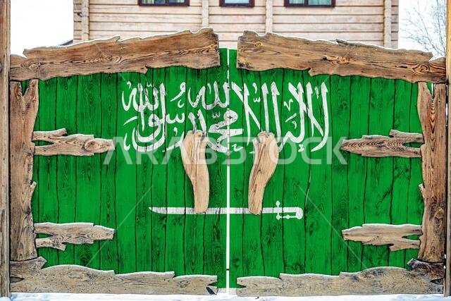 صورة مقرّبة للعلم الوطني للمملكة العربية السعودية على بوابة خشبية عند مدخل المنطقة المغلقة. مفهوم تخزين البضائع، والدخول إلى منطقة مغلقة.