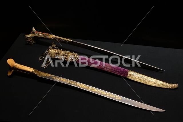 Ancient scimitars on a black background of precious metals with elaborate engraving in scabbards and without them