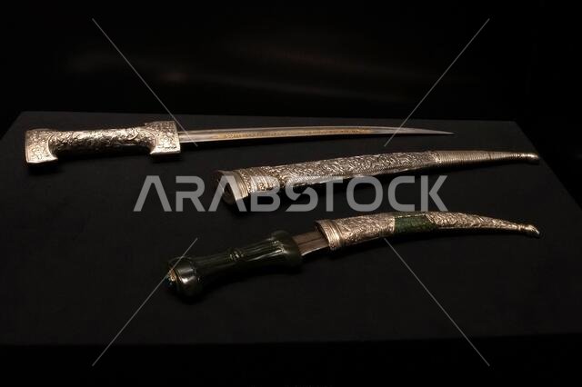 Ancient dagger on a black background of precious metals with elaborate engraving in scabbards and without them
