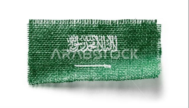 Saudi Arabia flag on a piece of cloth on a white background