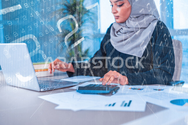 سيدة اعمال عربية خليجية سعودية تعمل على جهاز الحاسوب ، متابعة مخطط الرسم البياني للنمو الاقتصادي ، التداول في سوق الاوراق المالية ، مراقبة الاقتصاد والمعلومات المالية ، الاستثمار المالي ،خلفية رقميه للبورصه وسوق الأسهم بتقنية الهولوجرام 