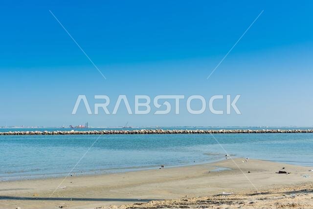 بحر أزرق وشاطئ مع سماء زرقاء في منتزه الكورنيش بالدمام، المملكة العربية السعودية